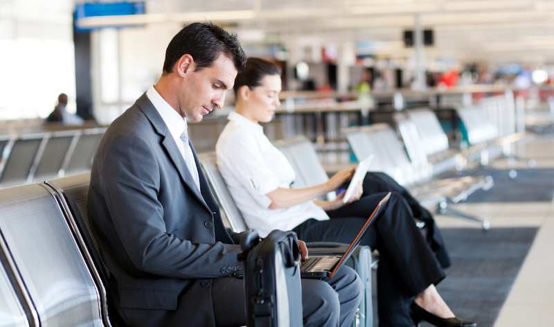 businessman working with his computer in airport while waiting for his plane