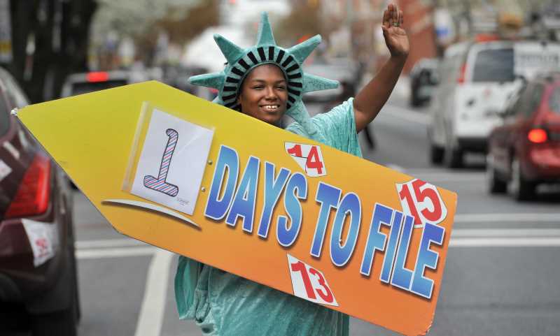 late tax filling, man dressed in statute of liberty holding a sign with the inscription ""1 day left""