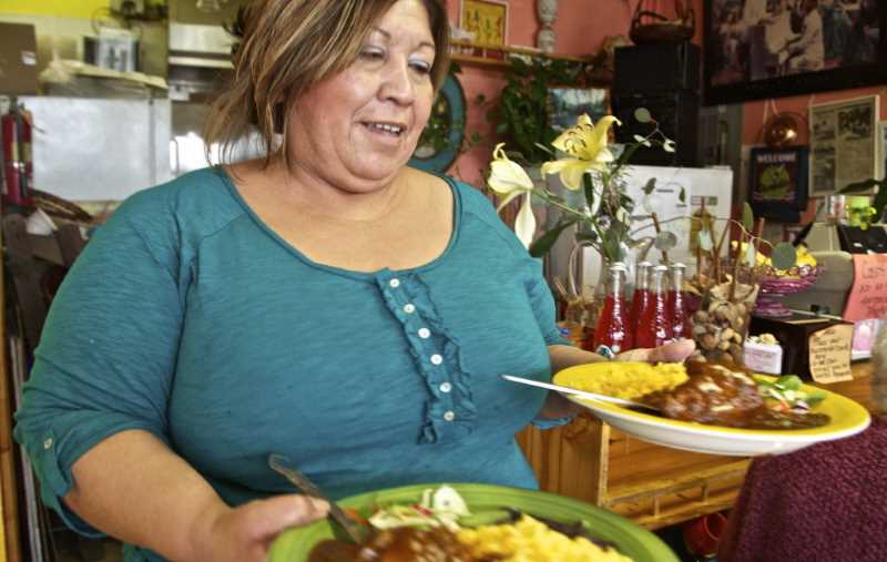 latina restaurant business owner serving food