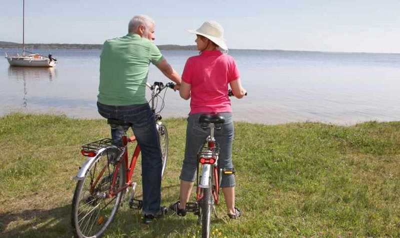 2 retirees driving bicycles looking at the sea