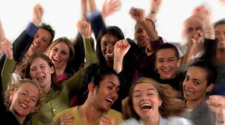 Group of happy, motivated employees cheering with hands up in expression of joy and enthusiam