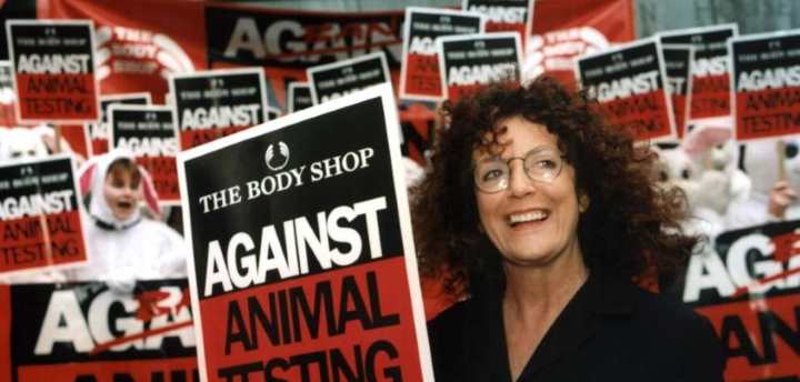 Anita Roddick with signs against animal crualty