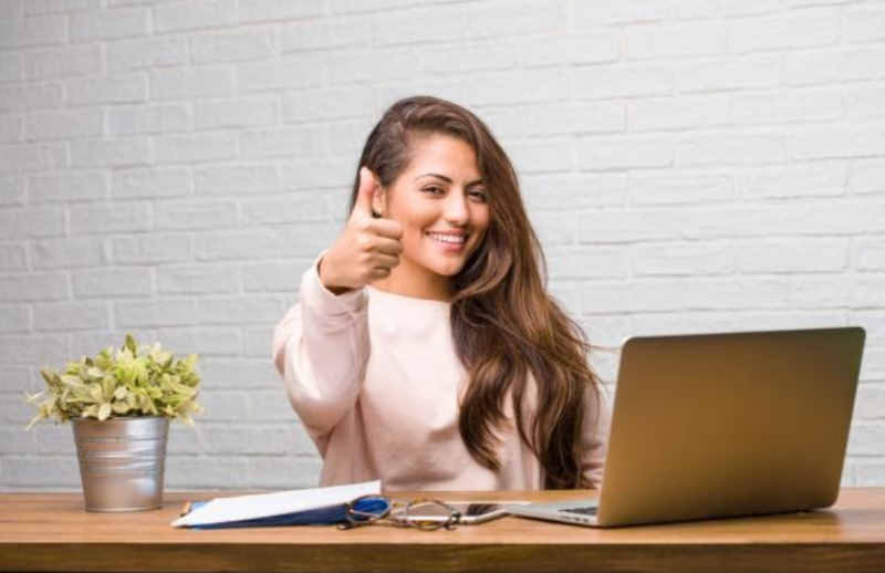 woman working on her laptop with thumb up