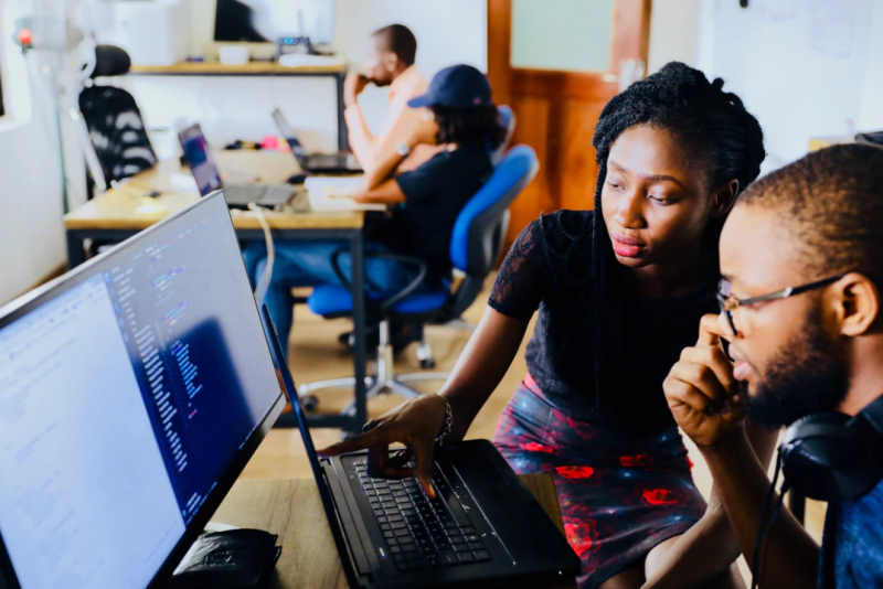 man and woman working on laptop