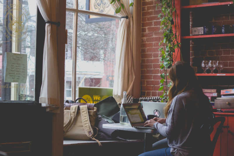 woman working on laptop from coffee shop