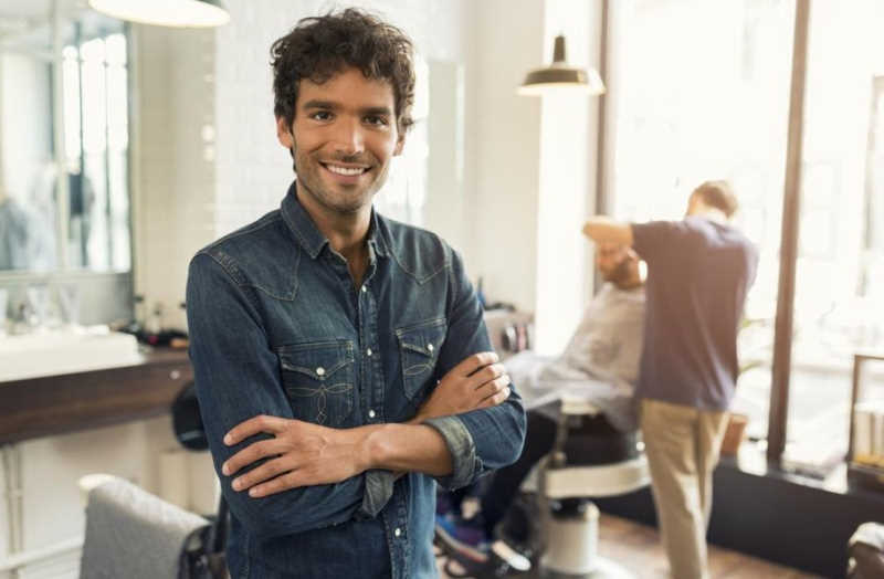 smiling man arms crossed in barber shop