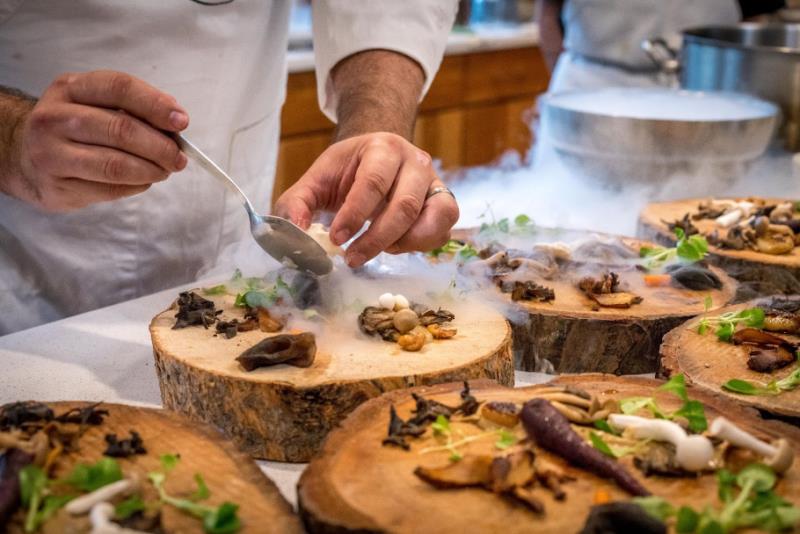 chef preparing dish on wood plates
