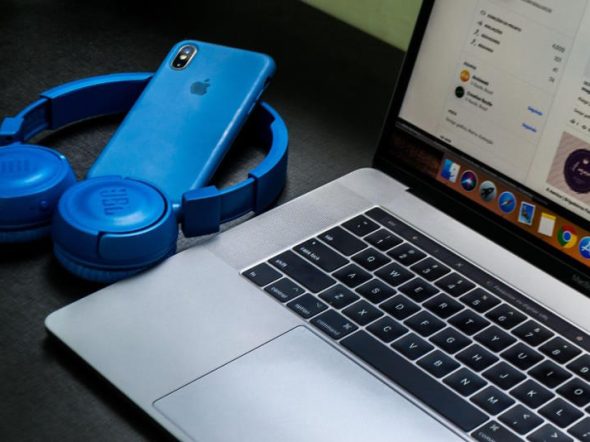 blue iphone headset and apple laptop
