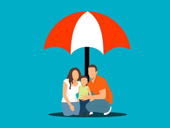 family sitting down protected by an umbrella