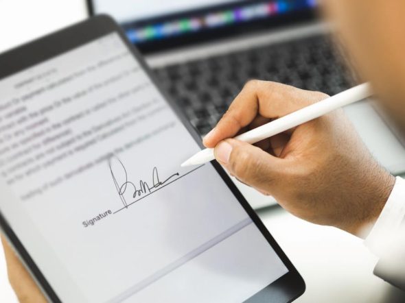 signing a document on a tablet