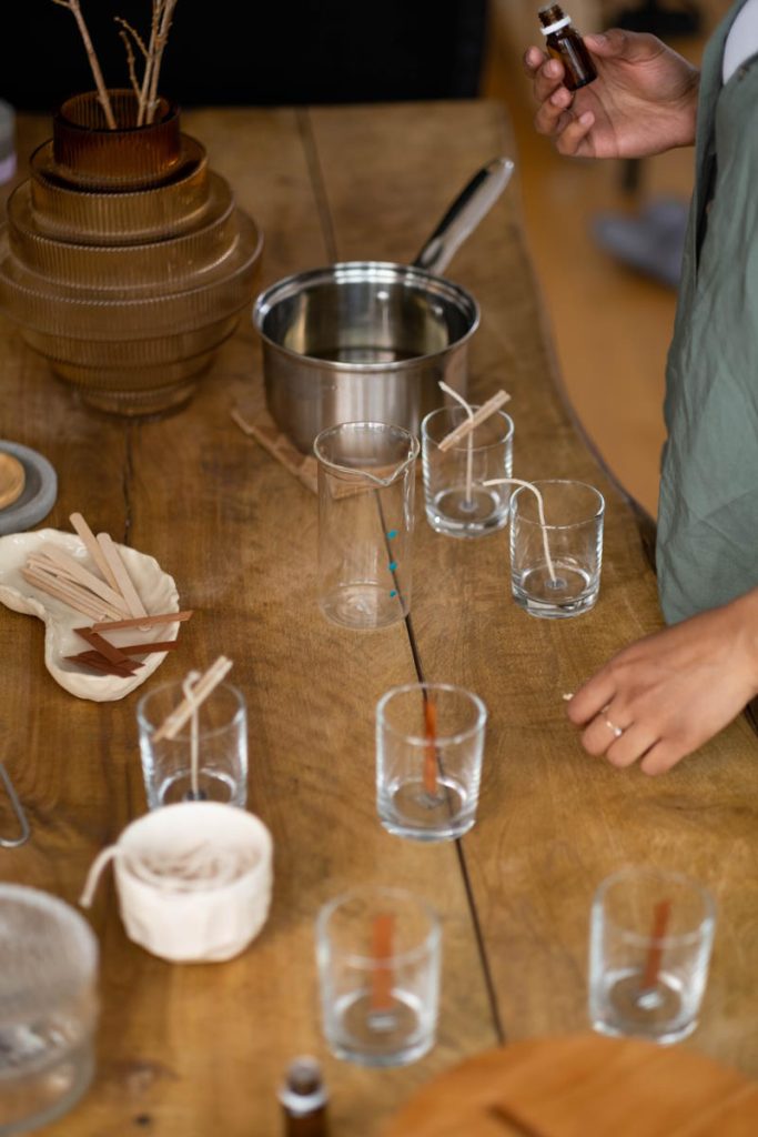 Person Making Candles on Clear Glasses