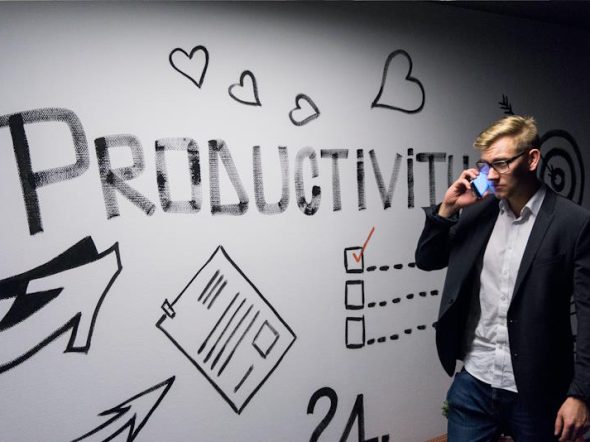 man looking at white board with the word productiity written on it