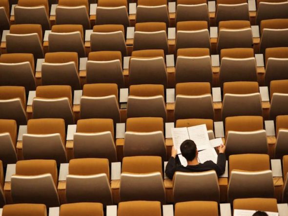 student alone in large conference room